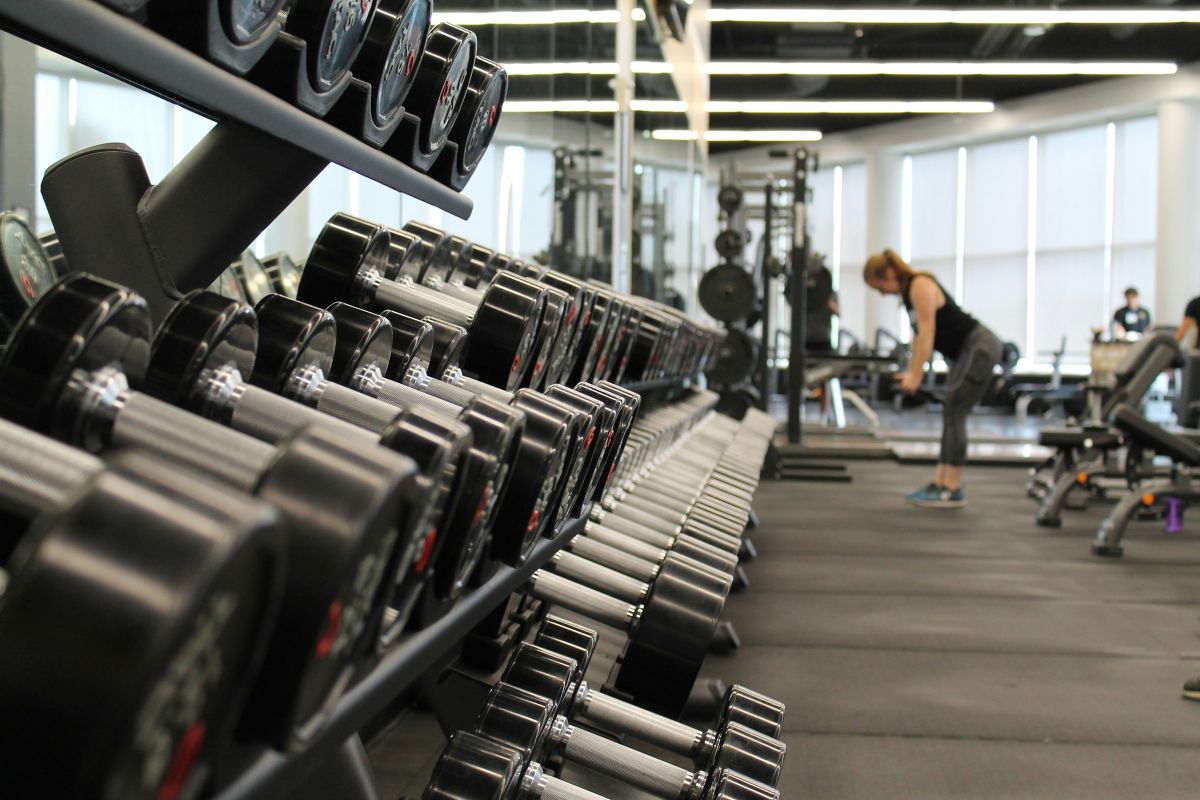 Styrketræning med vægte i et mørkt, nordisk fitnessrum